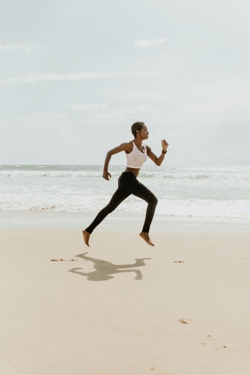Black woman running at the beach - 1079868