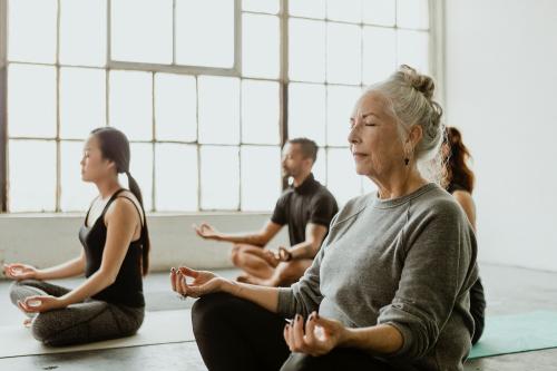Diverse people meditating in a yoga class - 1201640