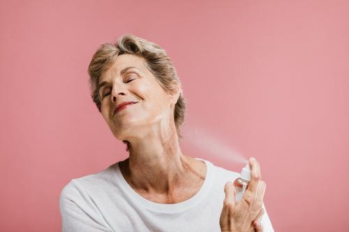 Elderly woman spraying cologne - 1203196