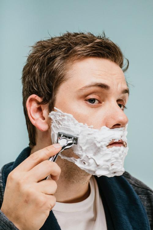 Young man shaving his beard - 1203276