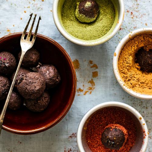 Chickpea truffles with dried fruit being coated in different types of powder - 1204789