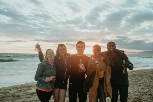 Cheerful friends drinking on the beach - 1080052