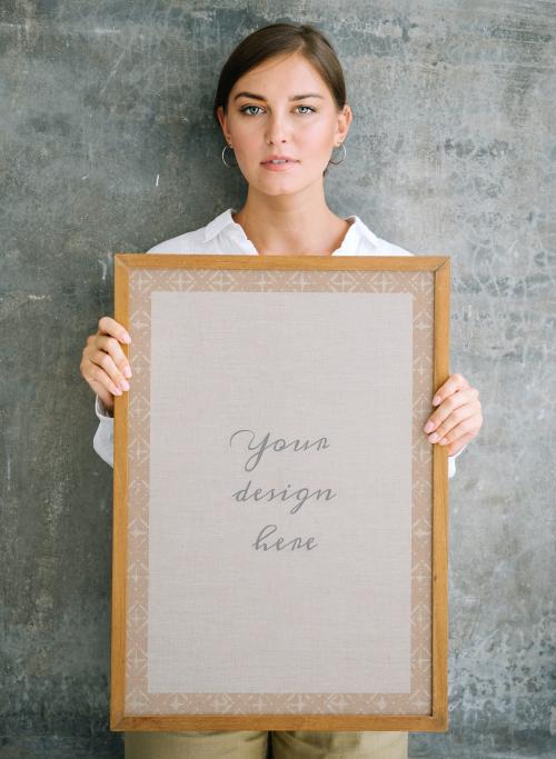 Woman holding a blank wooden photo frame mockup - 1215211