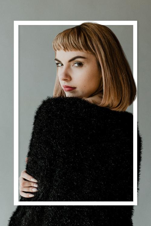 Brown hair woman in a black fluffy sweater looking back over her shoulder - 1216440