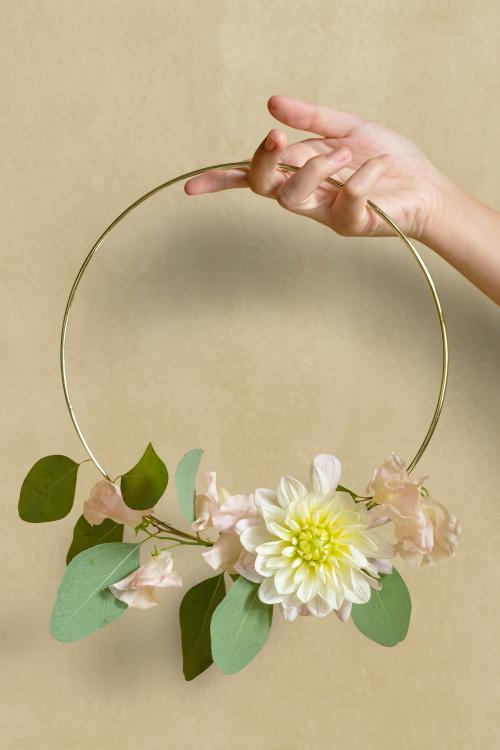 Woman holding a gold frame decorated with flowers - 1212443