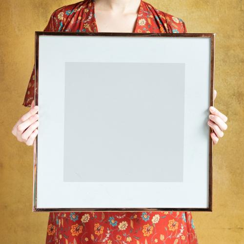 Woman showing a blank photo frame mockup - 1212455