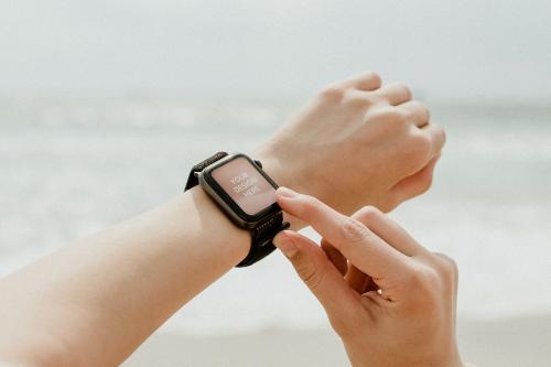 Woman checking her smartwatch mockup on the beach - 1079898