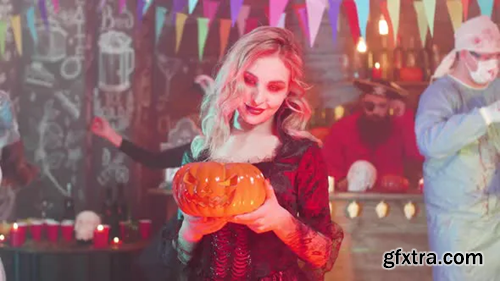 Videohive Sexy Vampiress with a Jack-o-lantern in Her Hands at a Halloween Party 23817445