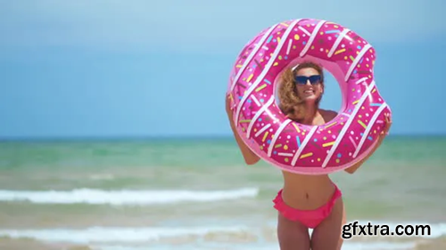 Videohive Beautiful Girl with Inflatable Donut Dancing Against the Sea 24001069