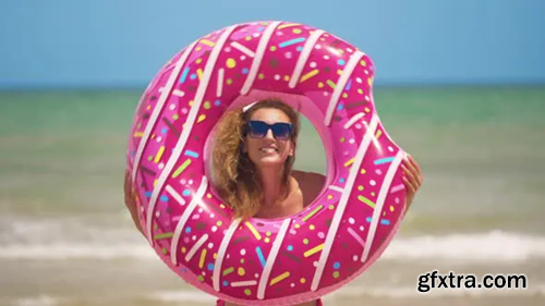 Videohive Beautiful Girl with Inflatable Donut Dancing Against the Sea 24001080