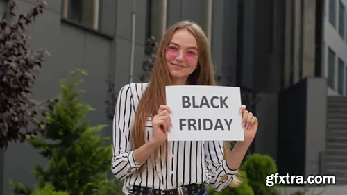 Videohive Joyful Teen Girl Showing Black Friday Inscription, Smiling, Looking Satisfied with Low Prices 28774045