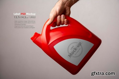 A male hand holding a red kitchen detergent bottle