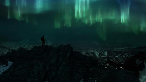 Videohive - Man on Icy Rock Summit of Snowy Mountain Panorama Watching Polar Lights Aurora Borealis - 41886108