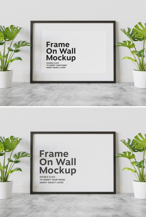 Adobe Stock - Black Frame Mockup Leaning on Wall with Plants - 438522491